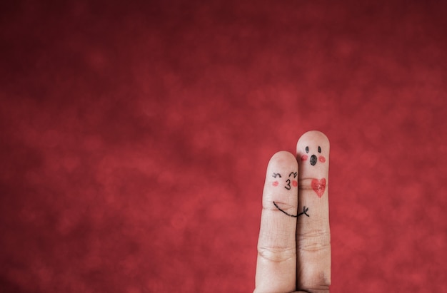Finger with emotion on red background