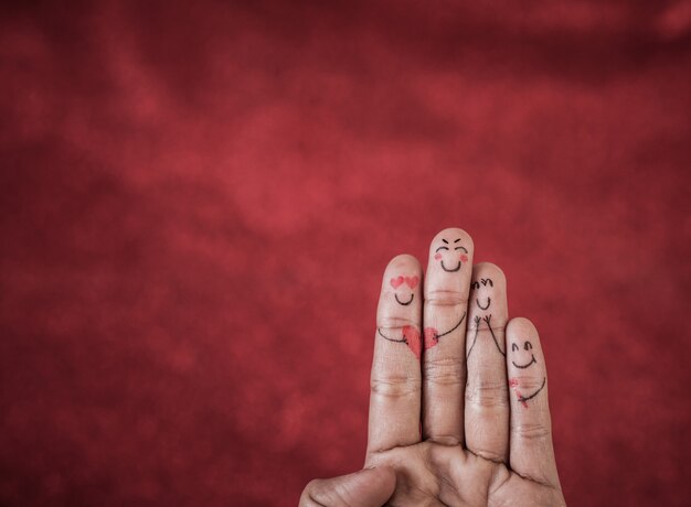 Finger with emotion on red background