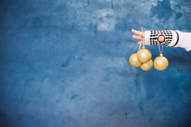 Fingers holding christmas balls