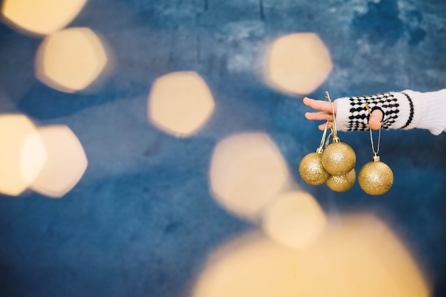 Fingers holding various christmas balls