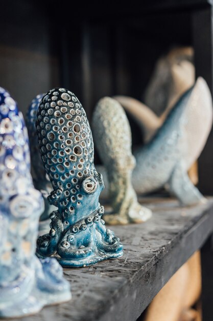 Finished pottery stands on a shelf in a pottery workshop. Ceramic whales and octopuses