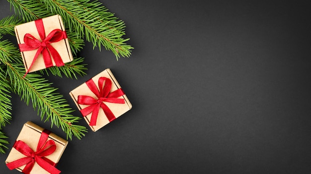 Fir branches and small gift boxes on a dark background