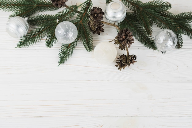 Fir tree branches with baubles on table