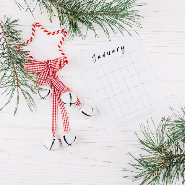 Fir tree branches with calendar on table