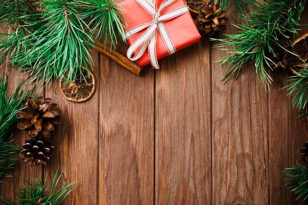 Fir twigs and box on wooden board