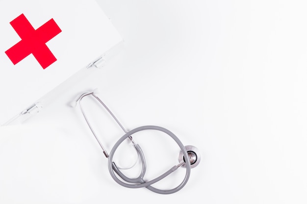 First aid kit with stethoscope on white background