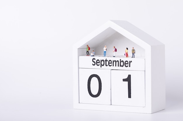 First day of school. Figurines of students standing on a calendar depicting the First of September