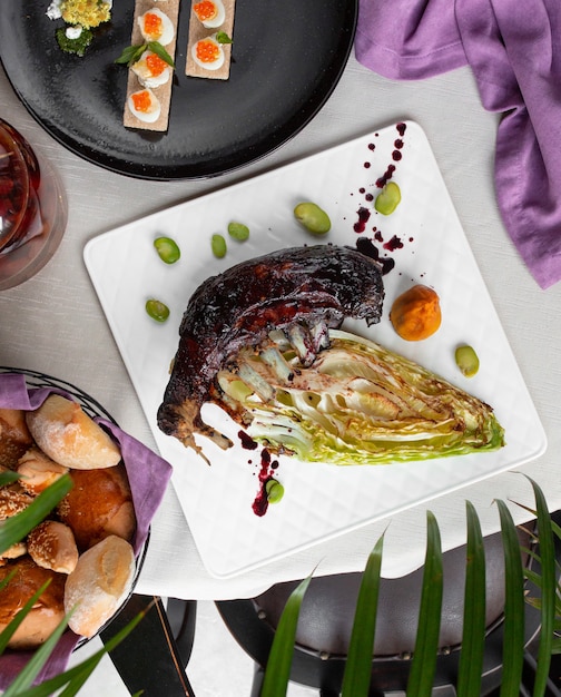 Fish barbecue with green dip sauce in a white plate.