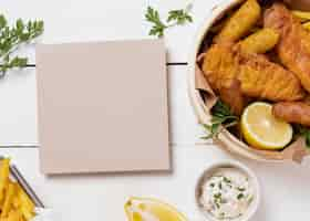 Free photo fish and chips in bowl with lemon and card