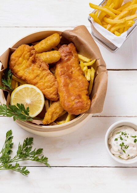 Fish and chips in bowl with lemon