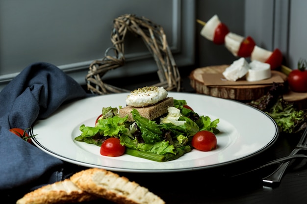 Fish cotlet served with lettuce salad, brown bread and tomatoes