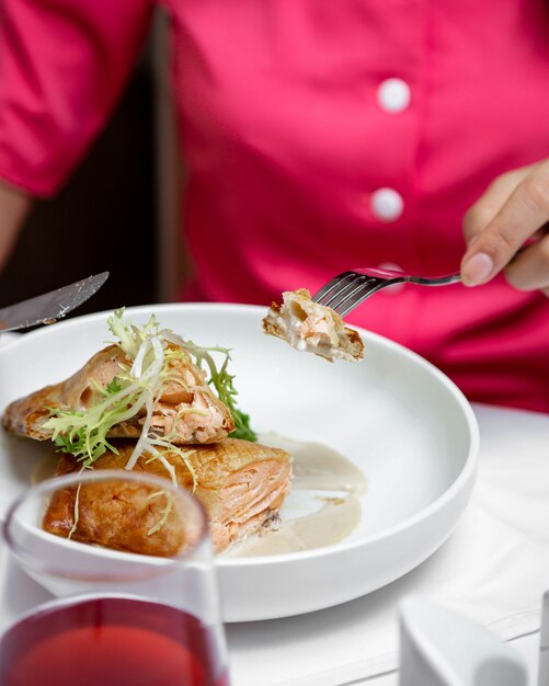 Fish in pastry and arugula in a white plate