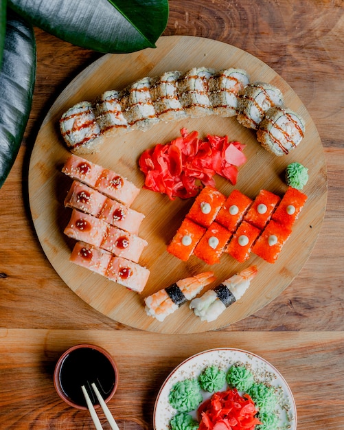 免费顶视图多彩的美味的鱼卷照片连同黑棕色的木质表面上酱汁