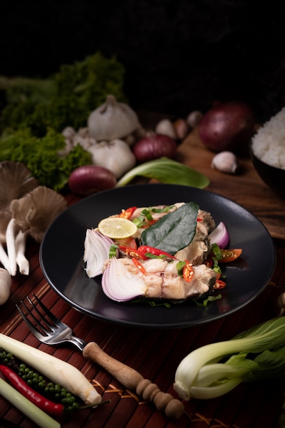 Free photo fish salad with lime, chili, lemongrass, onions, red onions, parsley and kaffir lime leaves in the plate