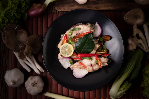 Fish salad with lime, chili, lemongrass, onions, red onions, parsley and kaffir lime leaves in the plate