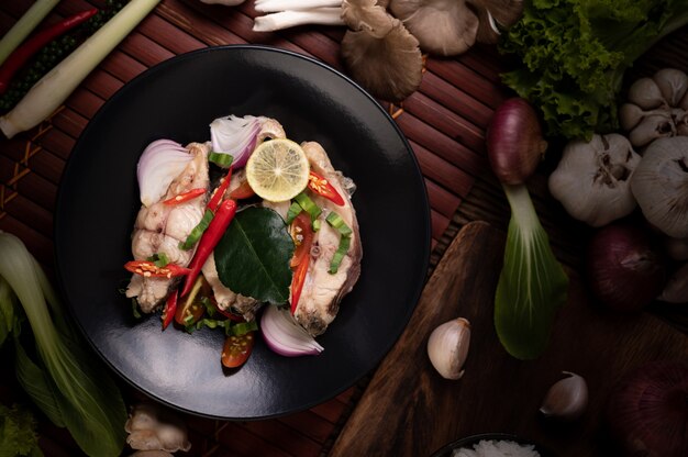 Fish salad with lime, chili, lemongrass, onions, red onions, parsley and kaffir lime leaves in the plate