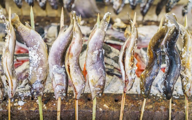 Fish with salt being grilled outdoors in Japan