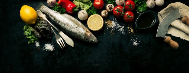 Рыба с овощами на черном фоне