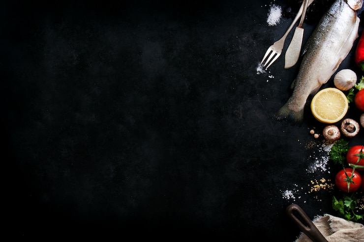 Free Photo fish with vegetables and cutlery on a black background