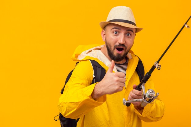 Fisherman giving thumbs up while holding fishing rod