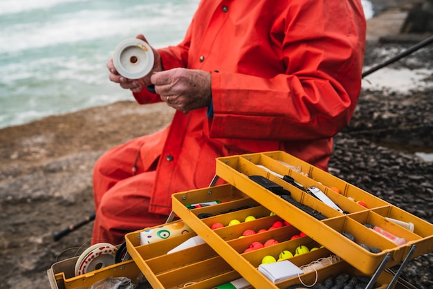 Fisherman with fishing equipment box.