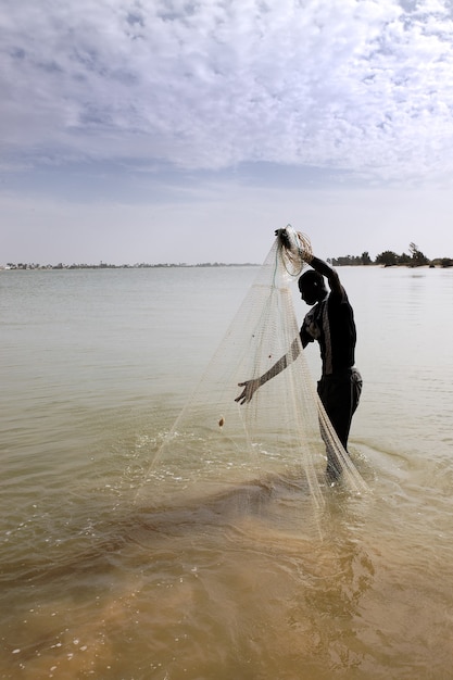 Free photo fisherman with net on the river