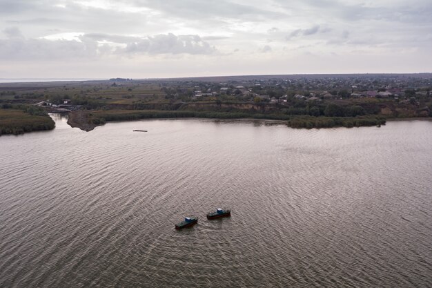 Fishing boats, floating the calm waters and going for fishing under a sky with clouds