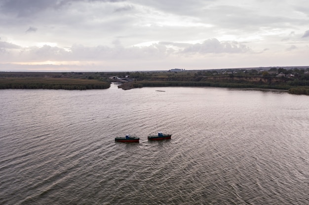 Fishing boats, floating the calm waters and going for fishing under a sky with clouds