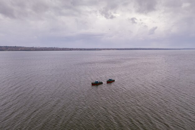 Fishing boats, floating the calm waters and going for fishing under a sky with clouds