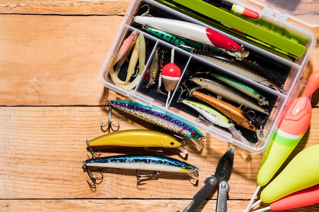 Fishing float and lure with plier on wooden desk