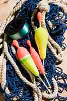 Free photo fishing floats and fishing reel on blue fishing net