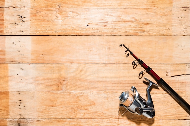Fishing rod and fishing reel on wooden backdrop