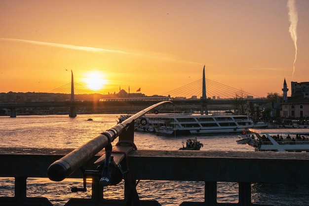 トルコの海を飛ぶカモメの素晴らしい黄色い夕日の前景での釣り道具