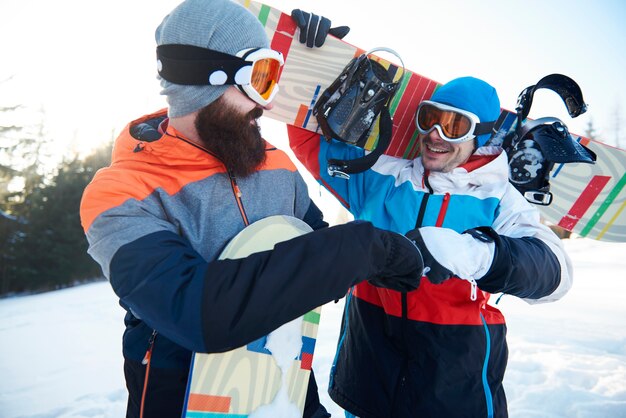 Fist bump of two male snowboarders