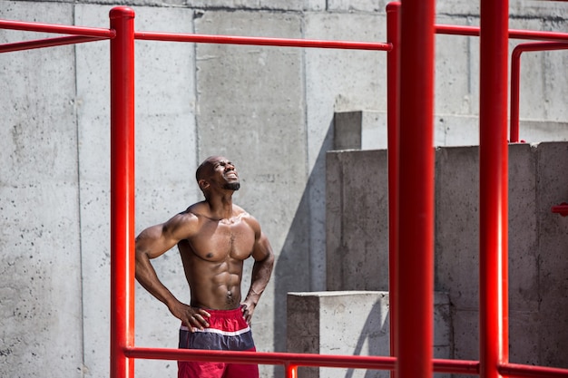 The fit athlete doing exercises at stadium. Afro or african american man outdoor at city. Pull up sport exercises. fitness, health, lifestyle concept