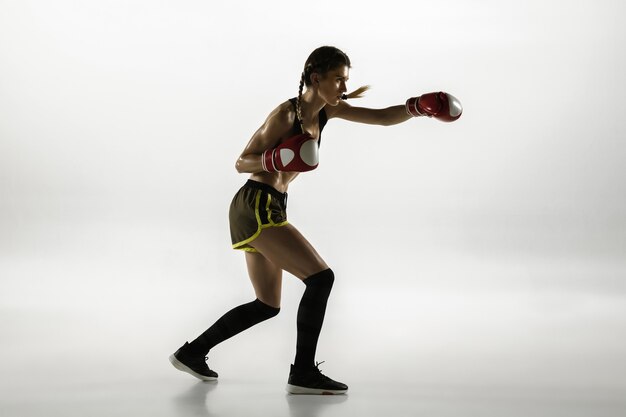 Fit caucasian woman in sportswear boxing isolated on white studio background.