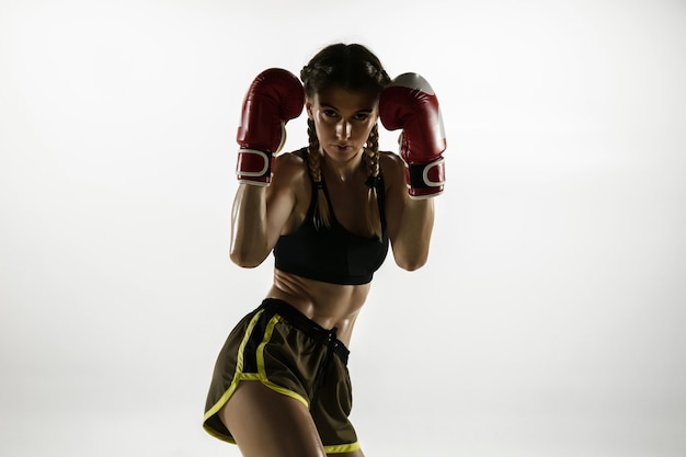 Free photo fit caucasian woman in sportswear boxing isolated on white  wall. novice female caucasian boxer training and practicing in motion and action. sport, healthy lifestyle, movement concept.