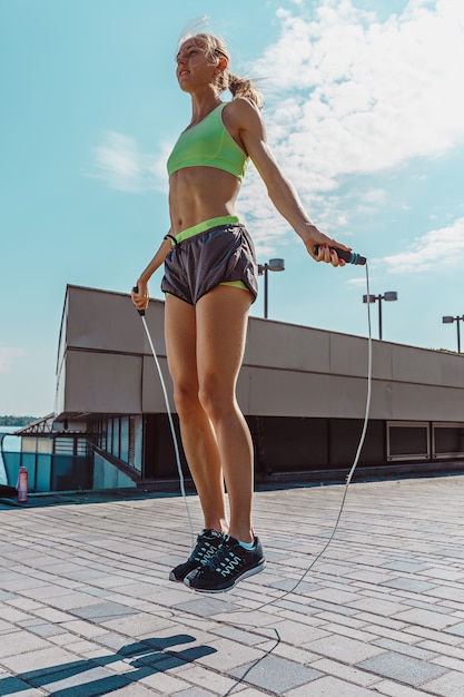 Бесплатное фото fit фитнес женщина делает упражнения фитнес на открытом воздухе