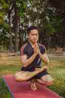 Free photo fit man doing yoga in the park