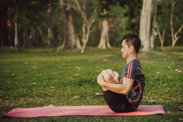 Free photo fit man enjoying yoga in the nature