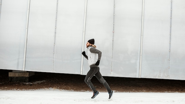 Fit man running alone outdoors full shot