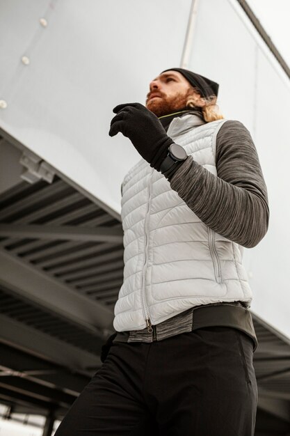 Fit man running outdoors medium shot