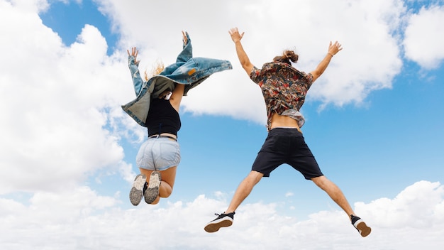 Foto gratuita l'uomo e la donna in forma saltano di gioia