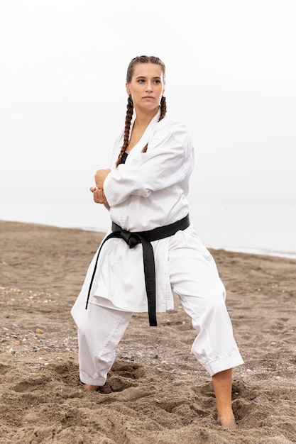 Free photo fit model training in karate costume