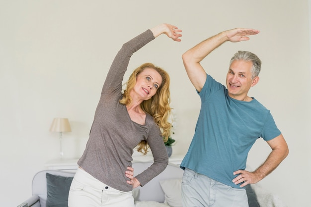 Free photo fit senior couple exercising indoors