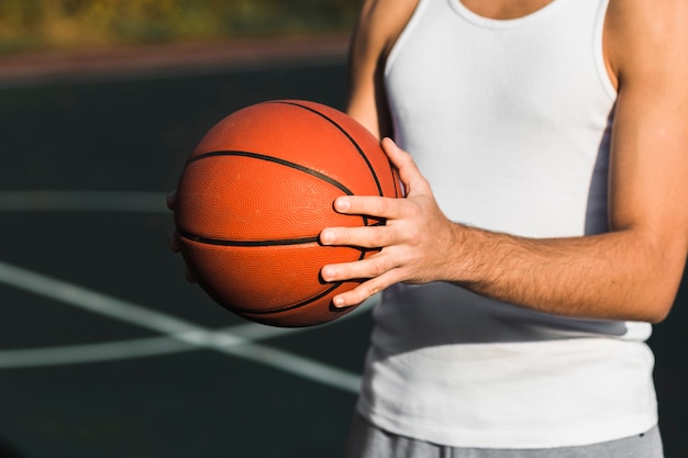 Fit unrecognisable athlete holding basketball