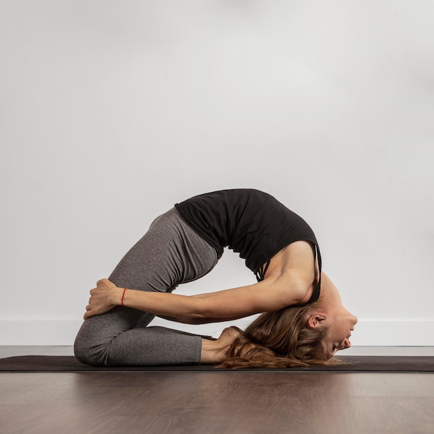 Foto gratuita montare la donna che fa yoga a casa