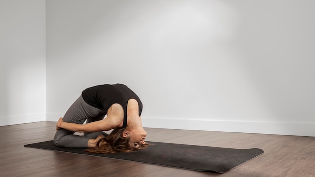 Foto gratuita montare la donna che fa yoga a casa