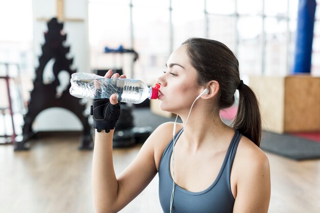 Fit woman in headphones drinking