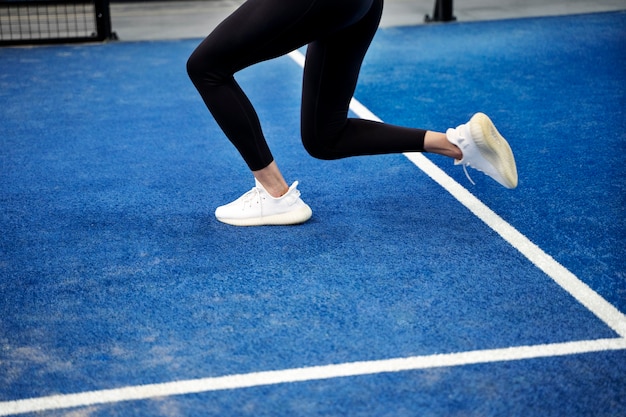 Fit woman playing paddle tennis side view